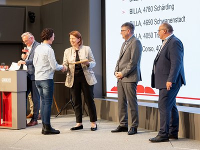 Übergabe einer Urkunde in Gold