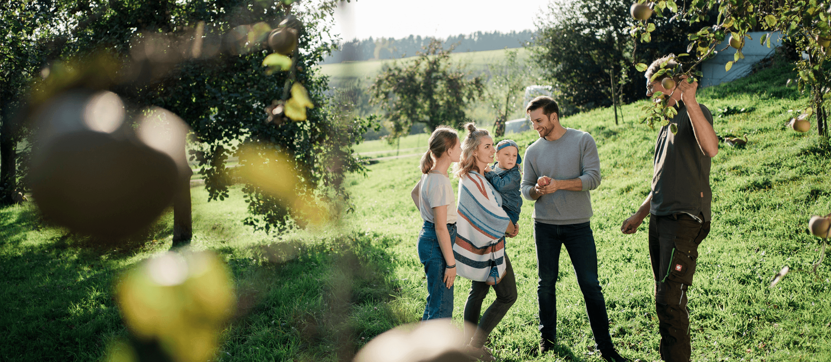Eine Familie im Obstgarten mit Norbert vom Pankrazhofer