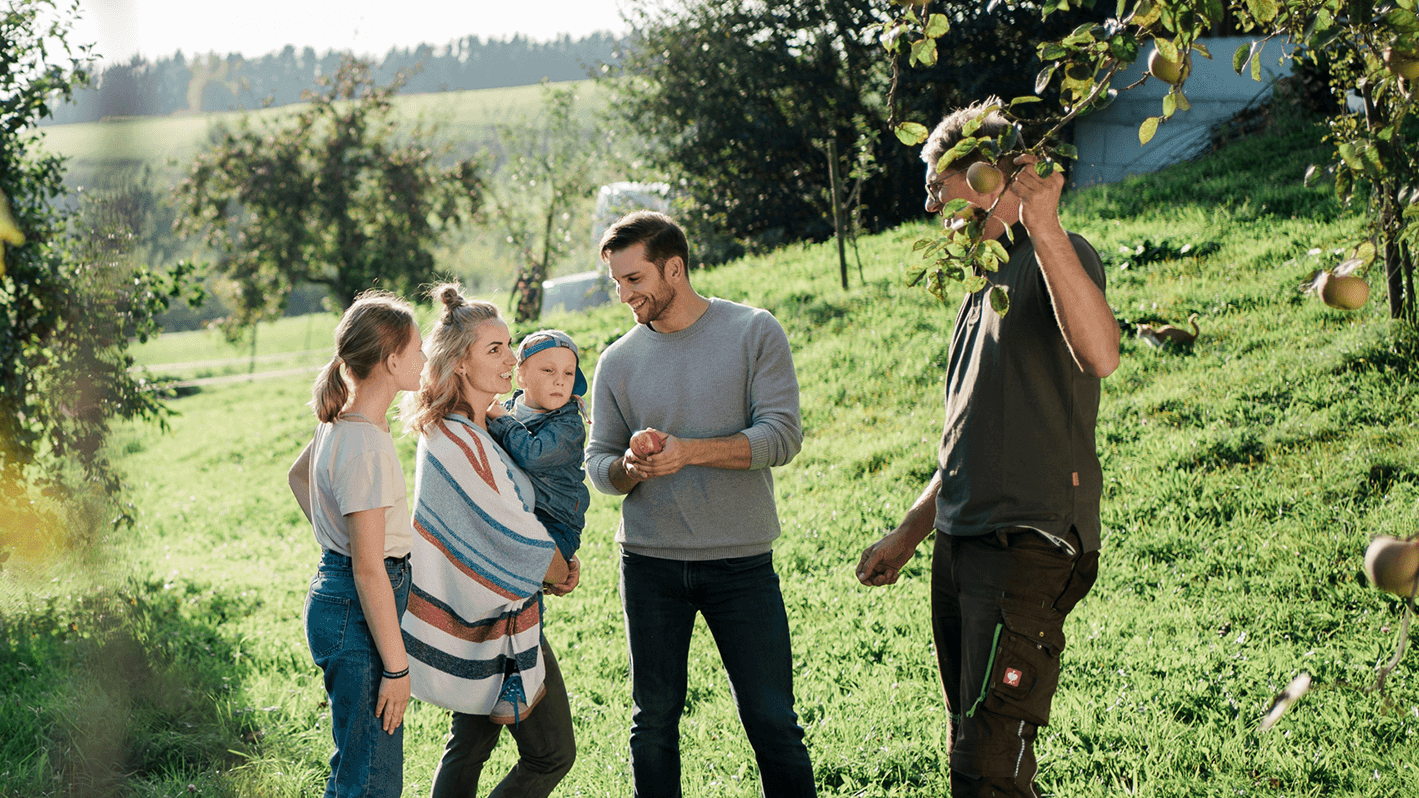 Eine Familie im Obstgarten mit Norbert vom Pankrazhofer