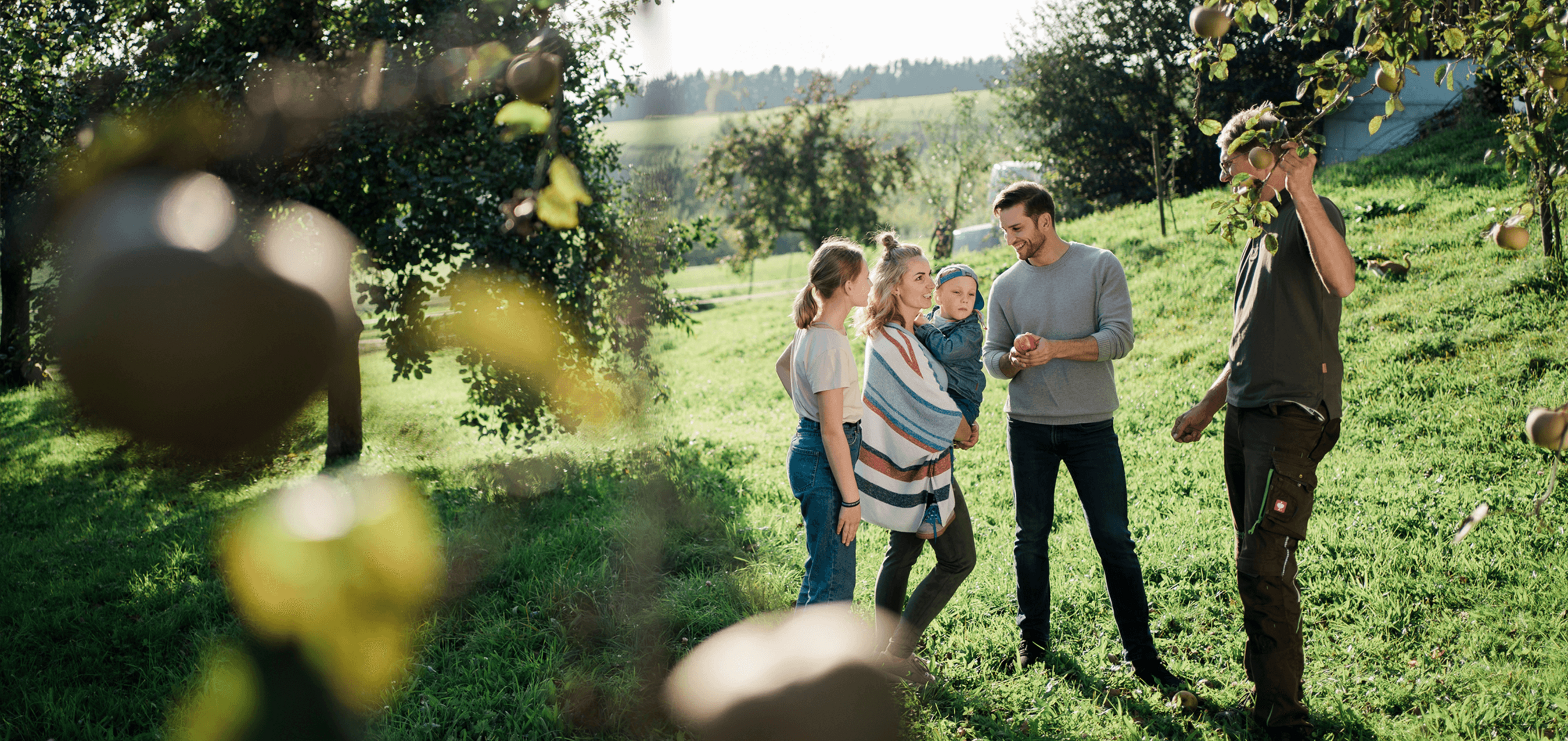 Eine Familie im Obstgarten mit Norbert vom Pankrazhofer