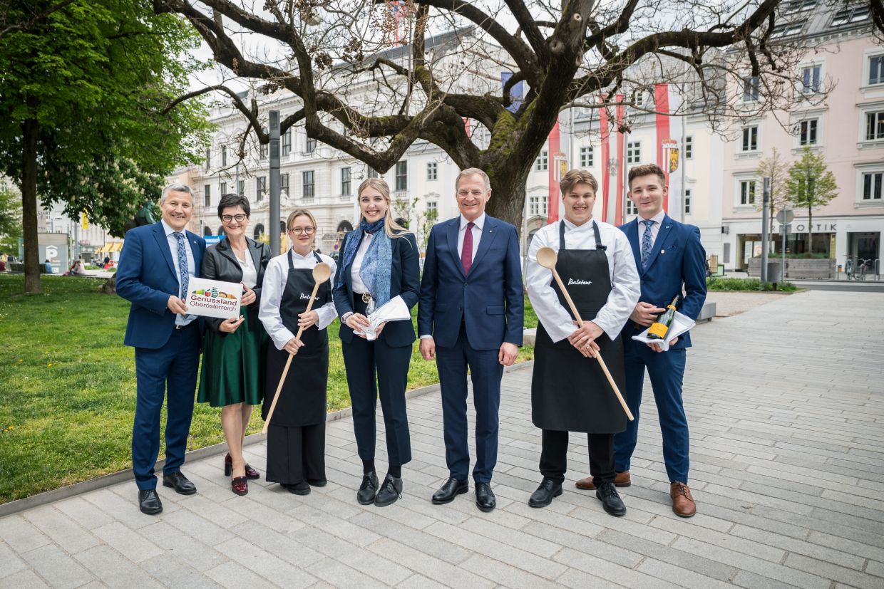 Feierliches Gruppenfoto mit den vier Schüler:innen, dem Landeshauptmann, dem Direktor der Baletour und Margit Steinmetz-Tomala